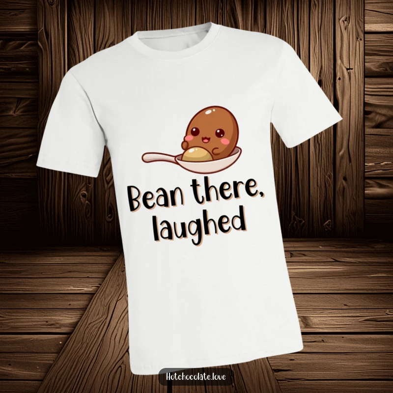 Funny cocoa bean giggling with delight while sitting on a tiny spoon, featured on a comfortable t-shirt.
